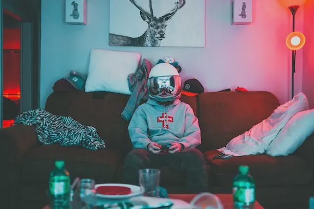 Boy in a virtual reality helmet playing with a joystick.
