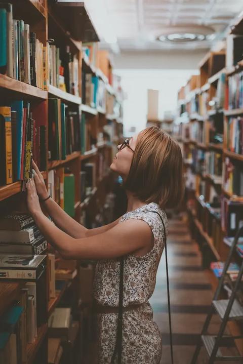Woman selecting a book in a library.