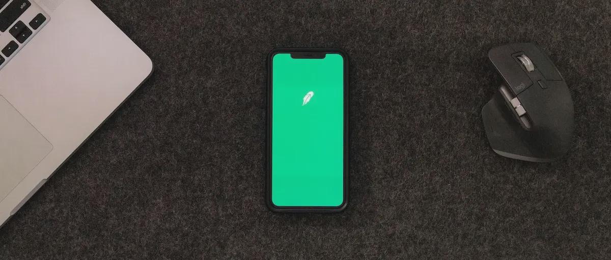 Photo of a phone on a desk with the Robinhood Logo