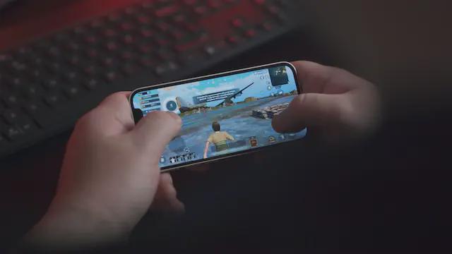 Young man playing PUBG Mobile with iPhone. 